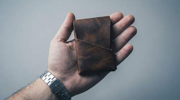 Editorial illustration for Full-Grain Heirloom or Slim Modern Bifold: Which Durable Minimalist Wallet Philosophy Fits You?